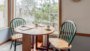 A round wooden table with two chairs, a notebook, and two cups. - Perfect Beach Cottage, Friendly, Walk to Beach and Seaside Promenade (Seaside)