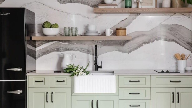 A kitchen with a marble backsplash, a black refrigerator, and light green cabinets. - Cozy Modern Studio Just 2 Blocks To Forsyth Park! (Savannah)