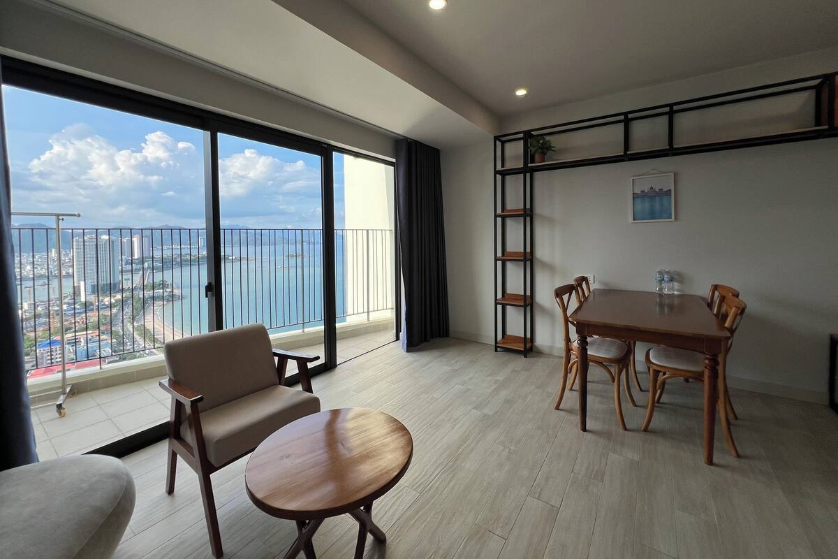 Een moderne woonkamer met een balkon en uitzicht op een stadsbeeld.