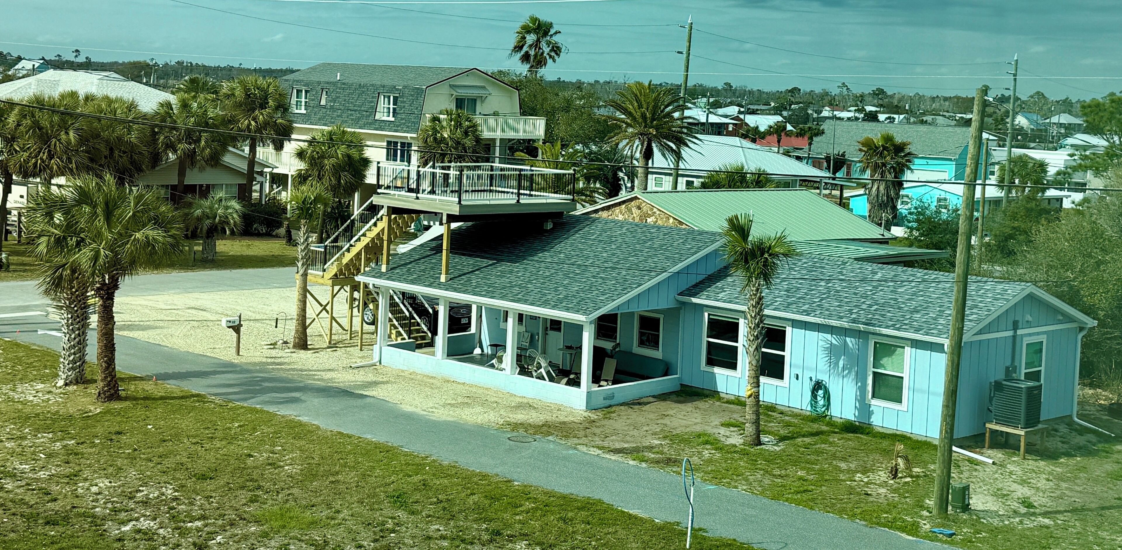 A two-story house with a balcony, a covered porch, and a small attached garage.