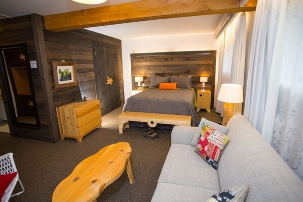 Relax in this inviting space with a large bed, sofa, and wooden bench.