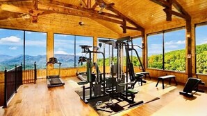 Ein Fitnessraum mit großen Fenstern und Holzvertäfelung.