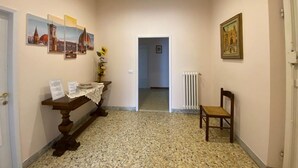 A hallway with a wooden bench, a radiator, and framed pictures on the walls. - CasaGiorgio a stone's throw from the historic center (Firenze)