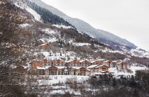 A row of log cabin-style buildings with a snowy mountain backdrop. - Apartment for 4 People in Orelle - Val Thorens - 3 Vallées Ski Area - Pool/Spa/Hammam (ORELLE)