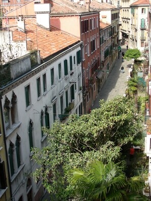 A narrow street lined with historic buildings, featuring balconies and traditional architecture. - Top floor, very bright, nice view, and convenient location. With an elevator. (Venezia)