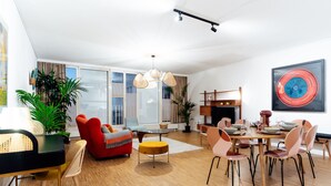 Una sala de estar moderna con comedor, ventanas grandes y chimenea.