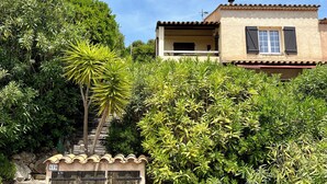 Une maison avec un toit en tuiles, un balcon et un portail.