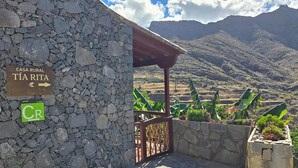 A stone building with a sign reading "CASA RURAL TÍA RITA" and a green sign with "CR". - Rural House Tía Rita La Gomera (Vallehermoso)