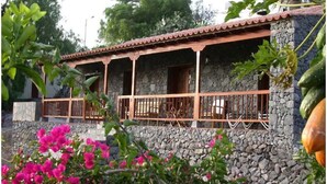 A stone building with a tiled roof and wooden balcony railings. - Rural House Tía Rita La Gomera (Vallehermoso)
