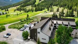 Un edificio con un letrero que dice "Clopper Valley", rodeado por un estacionamiento y un campo de golf.