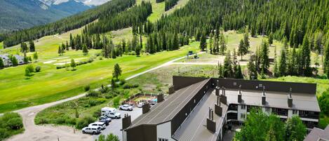 Un edificio con un letrero que dice "Clopper Valley", rodeado por un estacionamiento y un campo de golf.