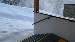 Et snæverkket uteområde med en trekonstruksjon og en steingmur.