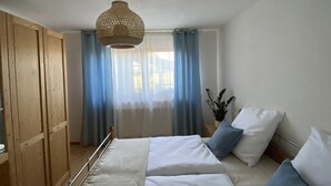Une chambre à coucher avec un lit, une armoire en bois et un luminaire suspendu.