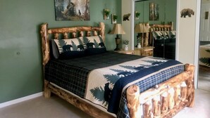 A bedroom with a wooden bed frame, a green wall, a painting, and a mirror. - Beach, lake & pool within walking distance! Outdoor fire pit area, Game room (Albrightsville)