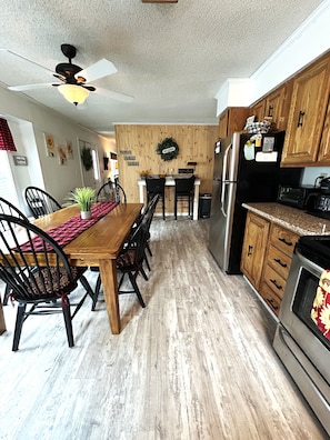 A kitchen with a wooden table, chairs, a refrigerator, and a microwave. - Beach, lake & pool within walking distance! Outdoor fire pit area, Game room (Albrightsville)