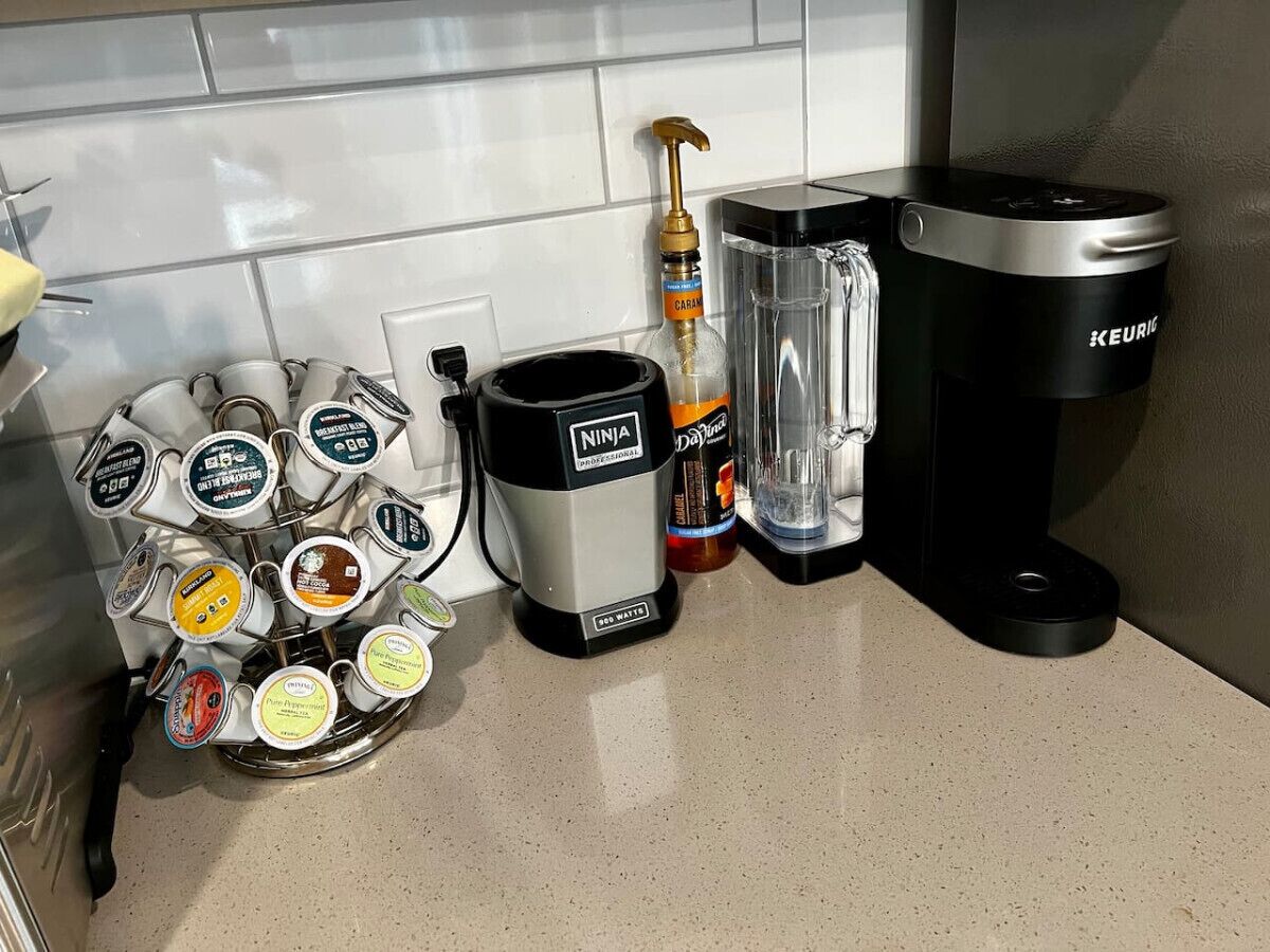 Una cocina con cafetera, dispensador de agua y máquina de café.