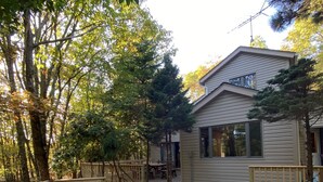 A hot tub on a wooden deck with a house in the background. - Serendipity, Sauna,Swimming Pool & Hot Tube, billiard, Secluded (Albrightsville)