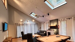 A spacious living room with a pool table, a sofa, a TV, and a ceiling fan. - Serendipity, Sauna,Swimming Pool & Hot Tube, billiard, Secluded (Albrightsville)