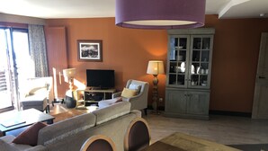 A living room with a sofa, a television, a cabinet, and a dining table. - Gorgeous appartment in Avoriaz (Avoriaz)