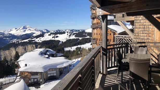 A wooden balcony with a view of snow-covered mountains and a restaurant. - Gorgeous appartment in Avoriaz (Avoriaz)