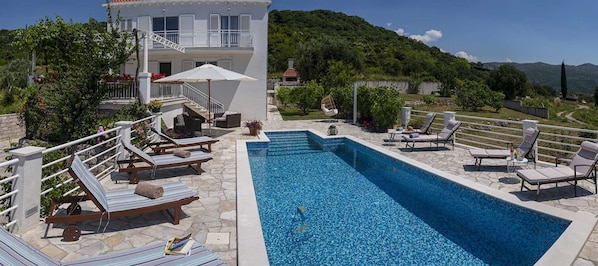 A swimming pool with lounge chairs and a staircase leading to a building.
