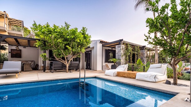 A swimming pool with lounge chairs and a pergola. - Two Bedroom Villa with Private pool just 100m from the Beach (Heraklion)