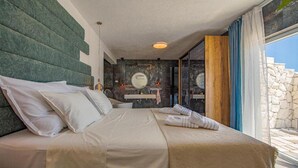Een moderne slaapkamer met een groot bed, een kaptafel met spiegel en een stenen muur.
