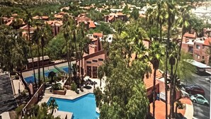 A resort with a swimming pool surrounded by palm trees and red-roofed buildings. - Tucson Escapes at Sabino Ventana King, queen, office, pets, pool, and pickleball (Tucson)