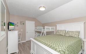 A bedroom with bunk beds, a television, and a door. - “Mermaid’s Dream” Short Walk from the Waves & Pool (Myrtle Beach)