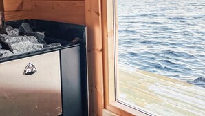 Eine Holzhütte mit Seeblick, rustikalem Interieur und einem Kühlschrank mit KOTA-Logo.