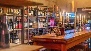 A bar with shelves of wine bottles and a candle holder on the counter. - luxurioese Ferienwohnung (Matrei in Osttirol)