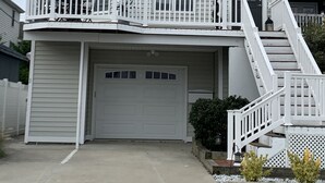 A two-story house with a garage, a balcony, and a staircase leading to the second floor.