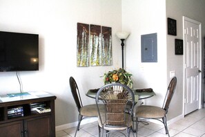 Enjoy meals in this cozy dining area with a round table and comfortable seating for two, featuring a flat-screen TV and a stylish cabinet with a reading nook.