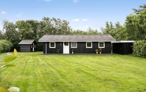 A black wooden house with a tiled roof, a small porch, and a well-maintained lawn. - Awesome home in Tarm with kitchen (Tarm)