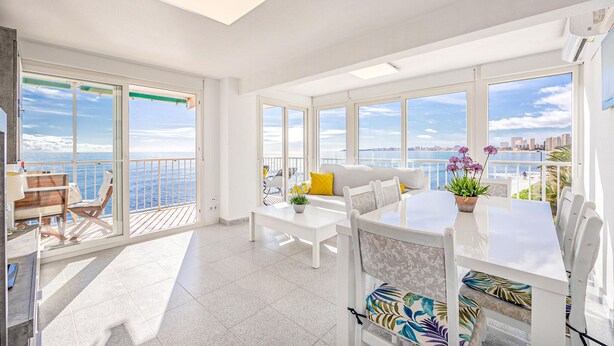 A bright, spacious balcony with a city view, a white sofa, and a dining table with chairs. - Pet friendly apartment in El Campello with WiFi (El Campello)