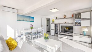 A modern living room with a dining area, a kitchen, and a TV. - Pet friendly apartment in El Campello with WiFi (El Campello)