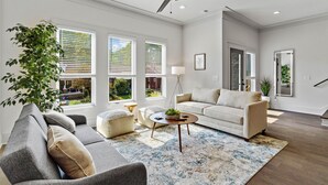A spacious living room with a grey sofa, a beige couch, and a coffee table with a plant. - *SLEEPS 12* Keep the Secret *EAST NASH6* 4BR* 4BA* (Nashville)