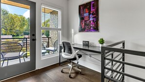 A modern office space with a desk, office chair, and a view of the outdoors through a door. - *SLEEPS 12* Keep the Secret *EAST NASH6* 4BR* 4BA* (Nashville)