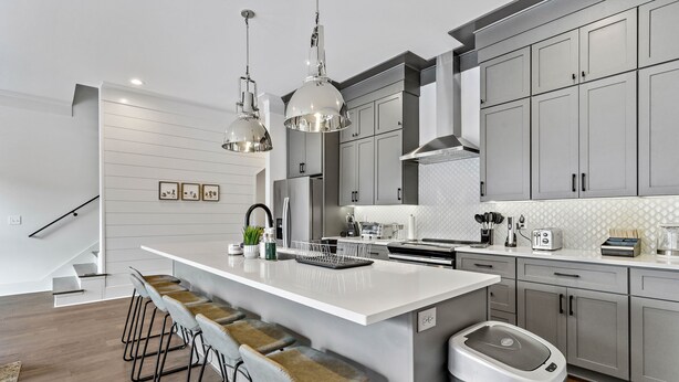 A modern kitchen with a large island, stainless steel appliances, and bar stools. - *SLEEPS 12* Keep the Secret *EAST NASH6* 4BR* 4BA* (Nashville)