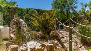 A naturalistic garden with a rock formation, a large agave plant, and a wooden fence. - Stunning home in Cehegín (Cehegín)