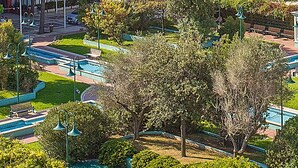 A park with a swimming pool, benches, and lamp posts. - Nice apartment in Cattolica with WiFi (Cattolica)