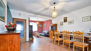 A dining area with a wooden table set for six, surrounded by six wooden chairs with cushioned seats. - Awesome home in Mirkopolje (Mirkopolje)