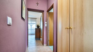 A hallway with purple walls, a wooden door, and a tiled floor. - Awesome home in Mirkopolje (Mirkopolje)