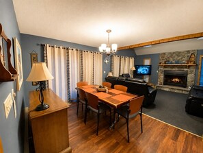 A living room with a fireplace, a dining area with a table and chairs, and a television mounted on the wall. - Visit Willow’s Place! All season Pocono Retreat!  Kayaks, Canoes and Pedal Boat! (Lake Ariel)
