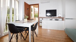 A modern living room with a dining area, a TV, and a small kitchen area. - 1 bedroom amazing apartment in Monticello (Monticello)