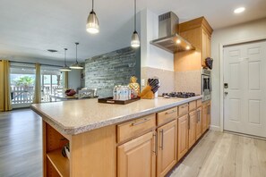 A modern kitchen with a large island, stainless steel appliances, and pendant lighting. - Spacious 4BR Near Strip with Private Pool, Free Parking (Las Vegas)