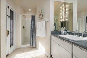 A bathroom with a shower, a sink, and a large mirror. - Spacious 4BR Near Strip with Private Pool, Free Parking (Las Vegas)