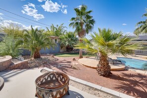 A backyard with a pool, palm trees, a fire pit, and a small shed. - Spacious 4BR Near Strip with Private Pool, Free Parking (Las Vegas)