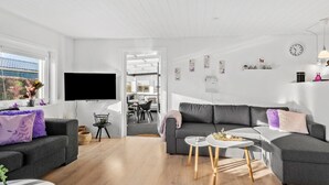 A modern living room with a grey sofa, a coffee table, and a TV mounted on the wall. - Amazing home in Haderslev with WiFi (Haderslev)