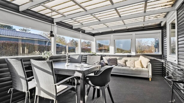 A sunroom with a glass ceiling, a dining table with chairs, a sofa, and a view of the outside. - Amazing home in Haderslev with WiFi (Haderslev)